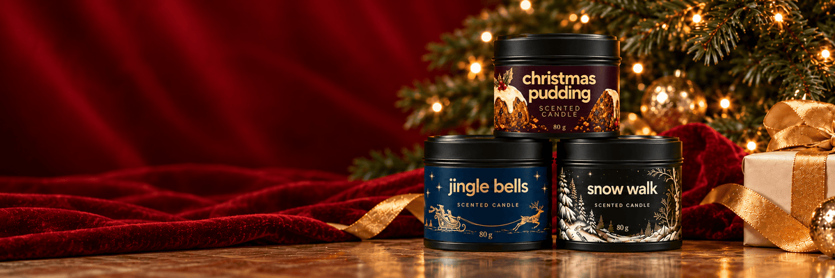 Bojuna Christmas Pudding candle stacked above Jingle Bells and Snow Walk candles, facing forward with Christmas greenery and red velvet.