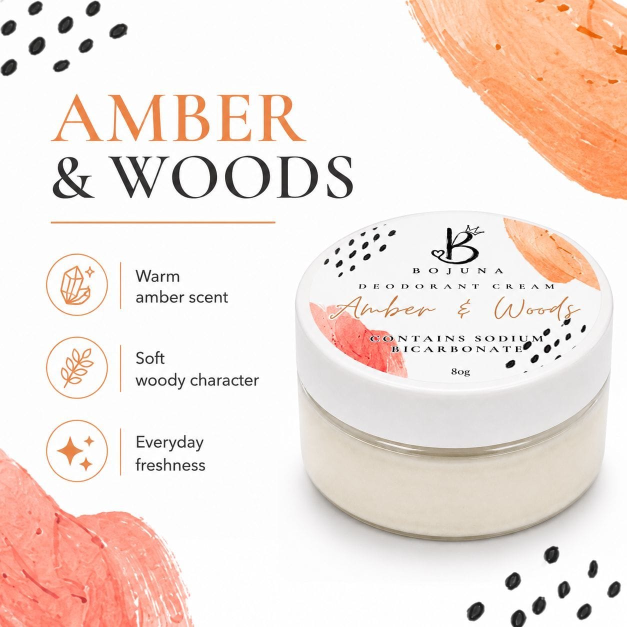 A jar of Bojuna Deodorant Cream in the 'Amber & Woods' scent, displayed on a clean white background with decorative peach-colored paint strokes and black dots. The left side features text and icons describing the warm amber scent, soft woody character, and everyday freshness.