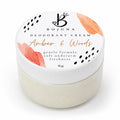 A 80g jar of Bojuna Deodorant Cream in the 'Amber & Woods' scent, featuring a white lid with coral floral illustrations and black polka dots, set against a clean white background.