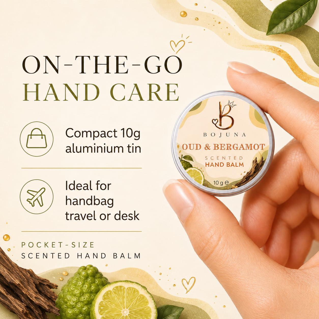 A hand holds a small round tin of Bojuna Oud & Bergamot Scented Hand Balm against a cream-colored background with marketing text and decorative citrus and wood elements.