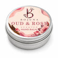 A round silver metal tin of Bojuna Oud & Rose Scented Hand Balm, featuring a pink floral label with rose illustrations and a crown logo on a white background.