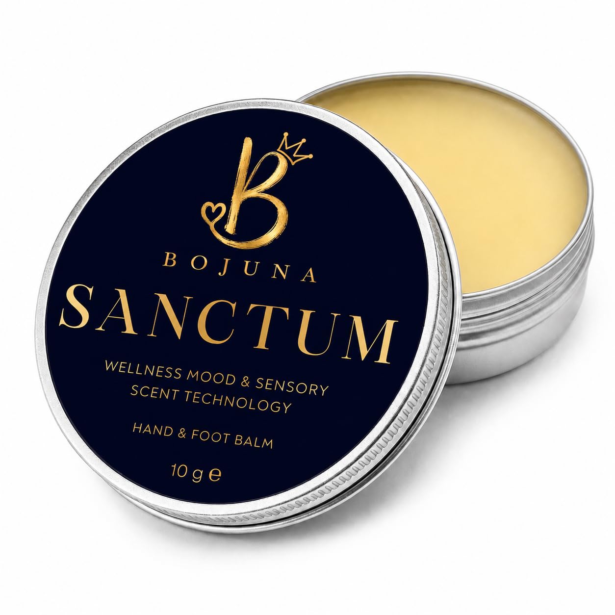 An open round metal tin of Bojuna Sanctum Hand & Foot Balm, showing the pale yellow balm inside, with the silver lid leaning in front displaying a navy blue label with gold lettering.