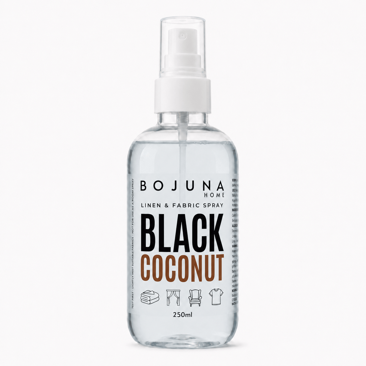 A clear plastic spray bottle of BOJUNA HOME Black Coconut Linen & Fabric Spray, containing a transparent liquid, with a white spray nozzle and a white label featuring black and brown text.
