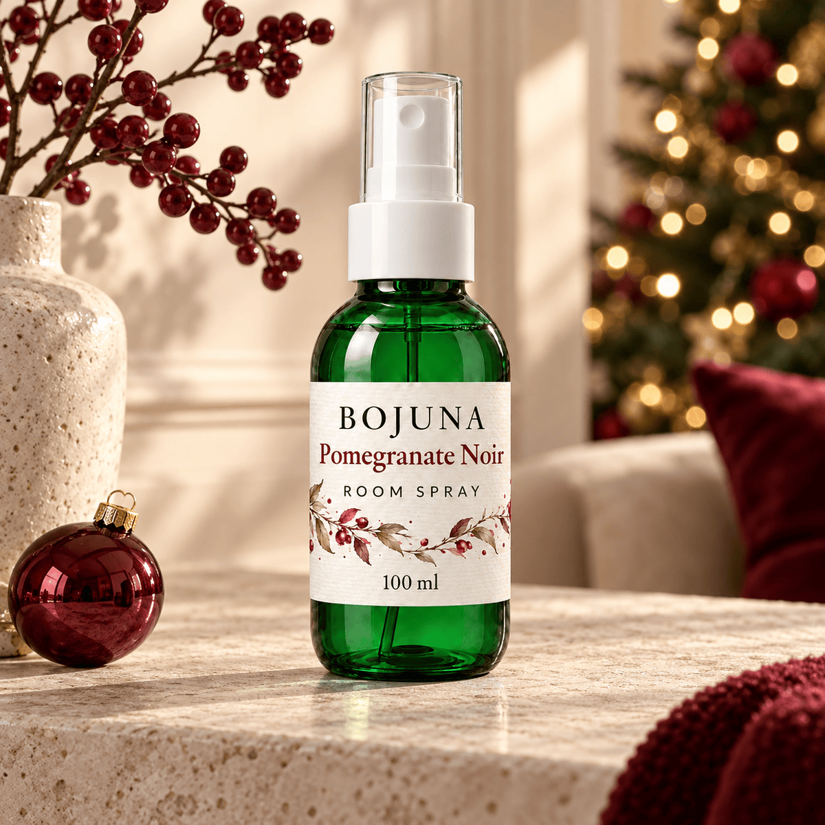 Bojuna Pomegranate Noir Room Spray 100 ml in an elegant Christmas setting with soft festive lights.
