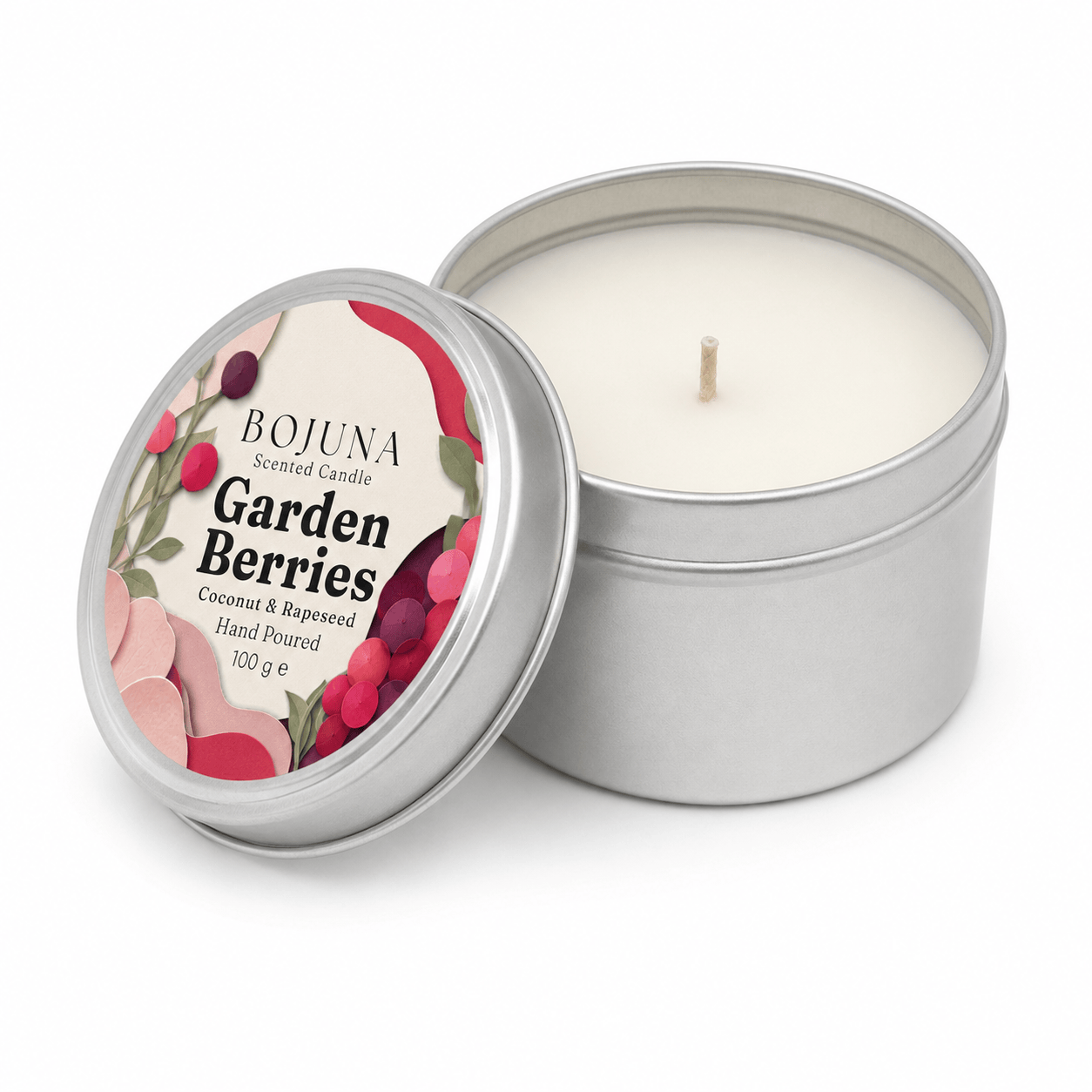 An open silver tin candle next to its lid, which features a colorful label reading 'BOJUNA Scented Candle Garden Berries'. The candle wax inside is a creamy off-white color, and the tin has a single wick.