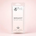 A packaged fragrance wax melt in a clear plastic clamshell package labeled 'Bojuna Bergamot & Earl Grey' on a soft pink background.