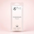 A packaged wax melt in a clear plastic clamshell package with a white insert card. The card reads 'BOJUNA' at the top and 'POMEGRANATE Noir' in the center, with additional text 'COCONUT & RAPESSEED DARK / FRUITY' and 'NET WEIGHT 50g' at the bottom.